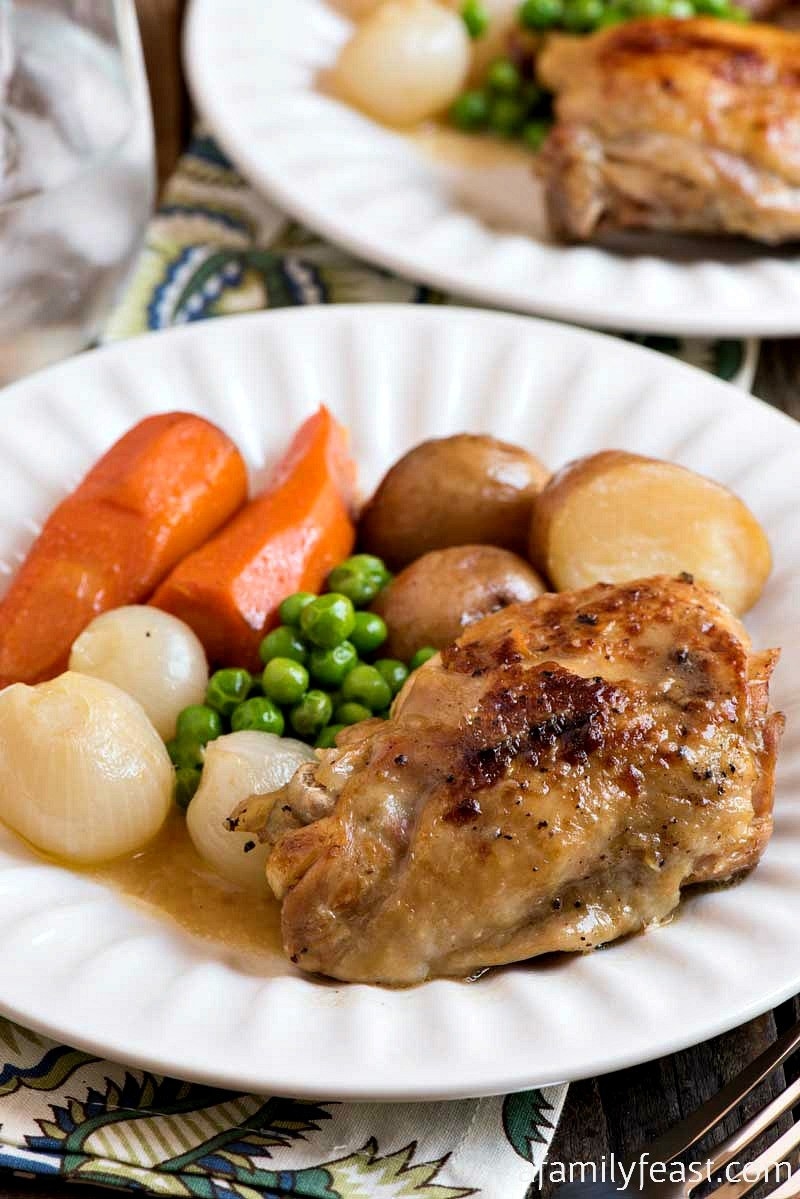 peas, onions, carrots, potatoes and chicken on a plate