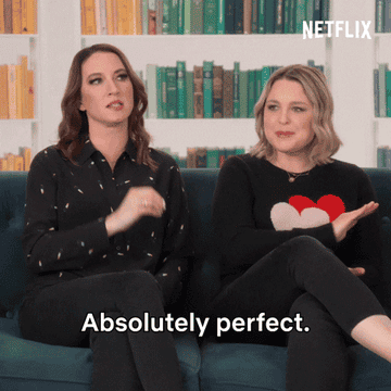 hosts of the home edit sitting on a couch and saying absolutely perfect