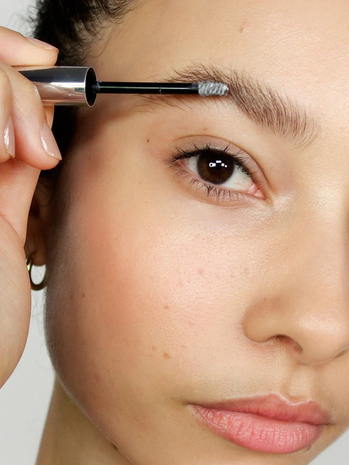 Model putting the clear gel on their brow