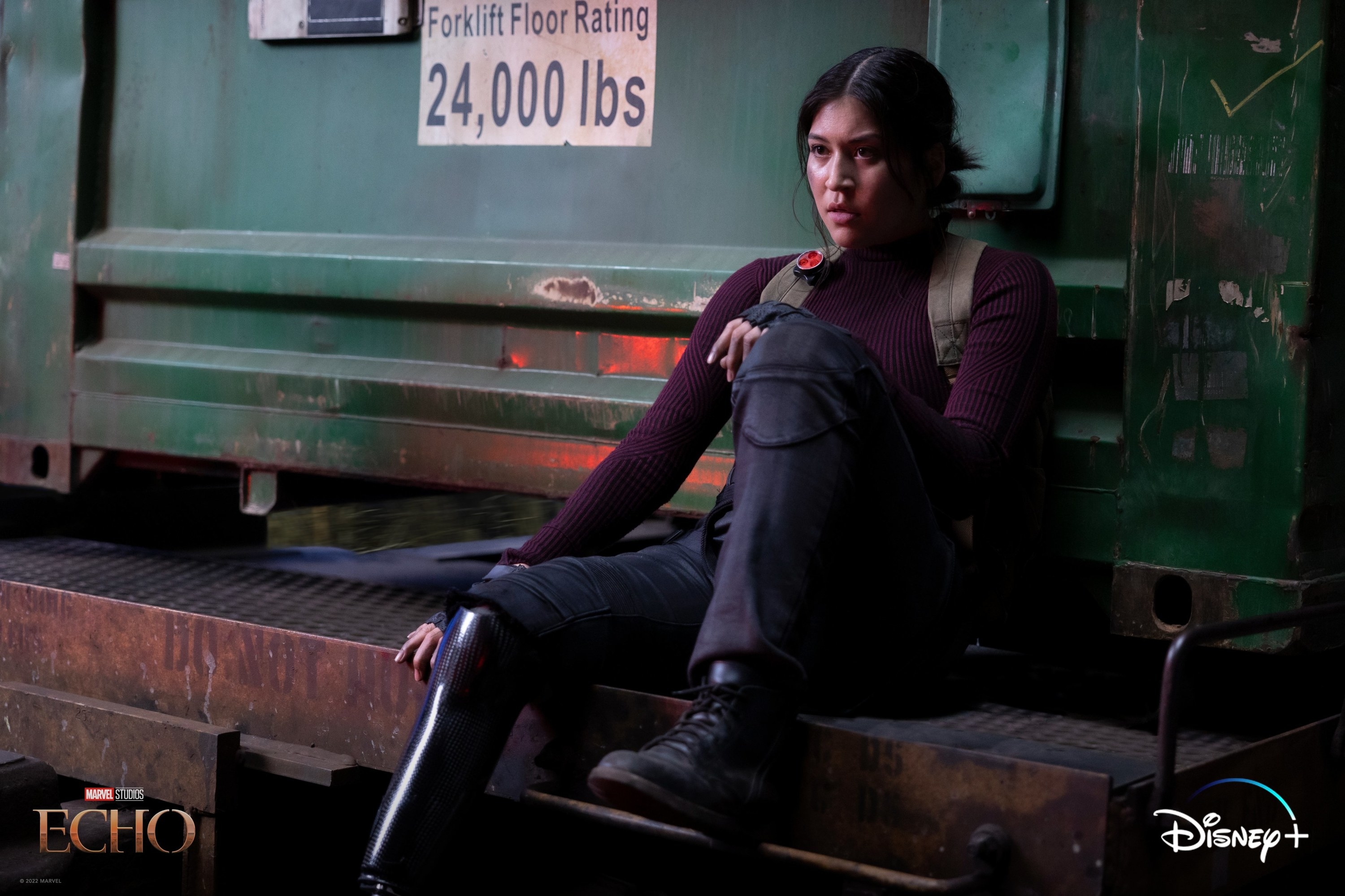 woman in combat boots sitting by a freight container