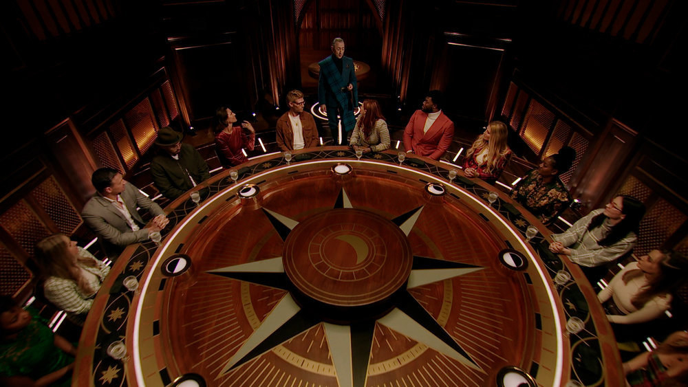 Contestants sit at the round table