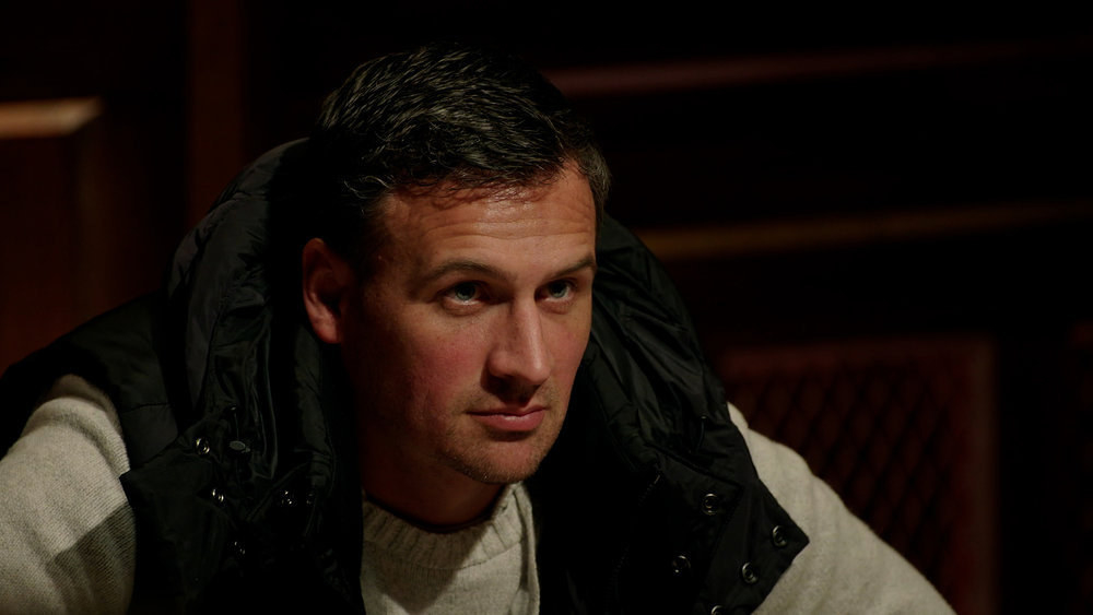 Ryan Lochte sits at a table