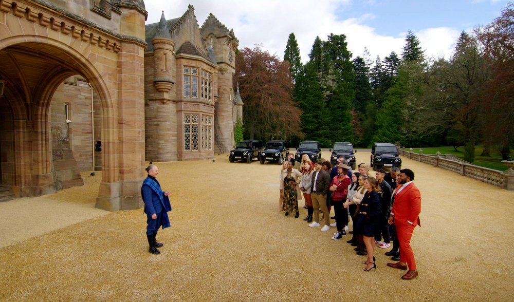 The cast of Traitors and Alan Cumming stand outside a Scottish castle