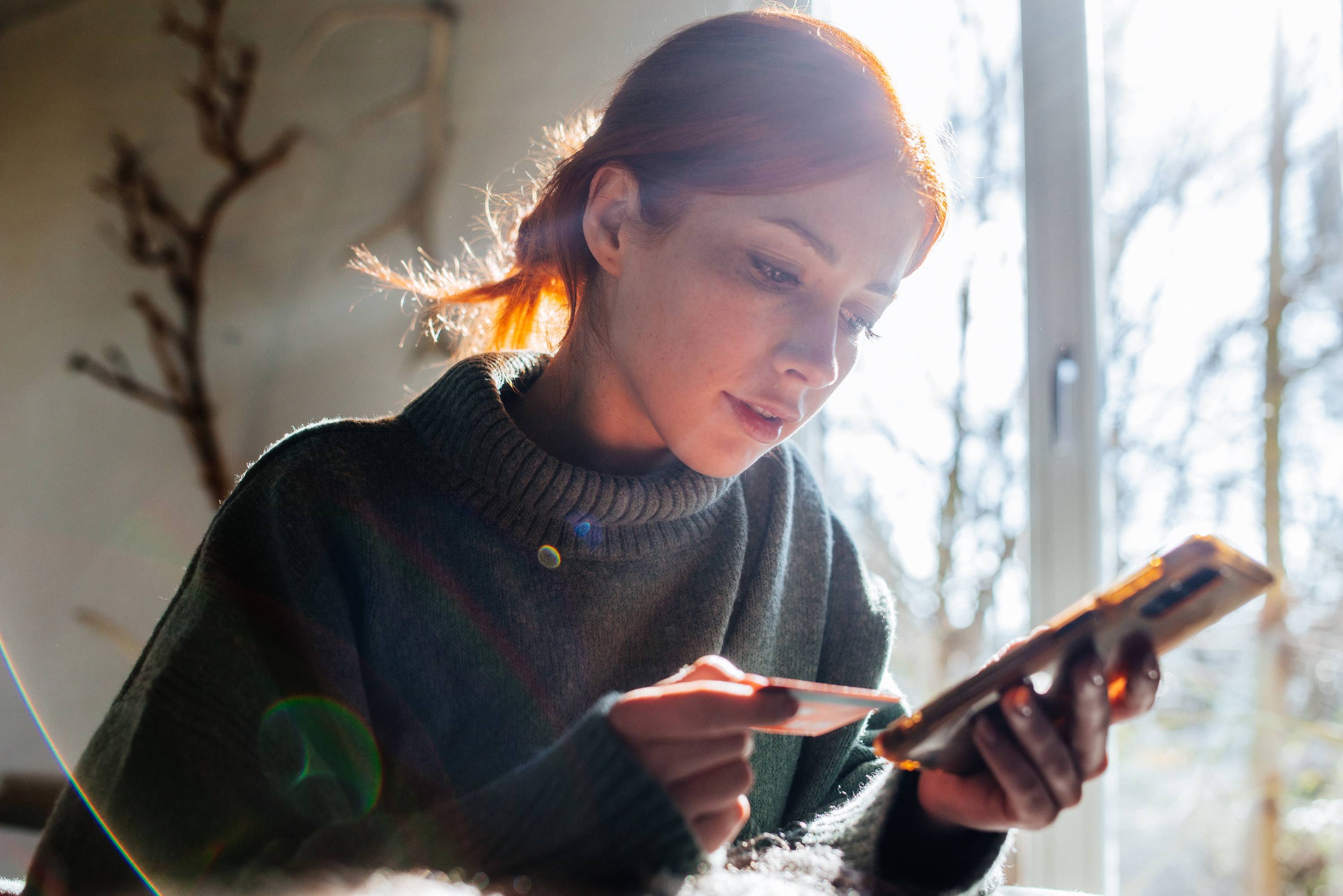 woman shopping on a smartphone with her credit card