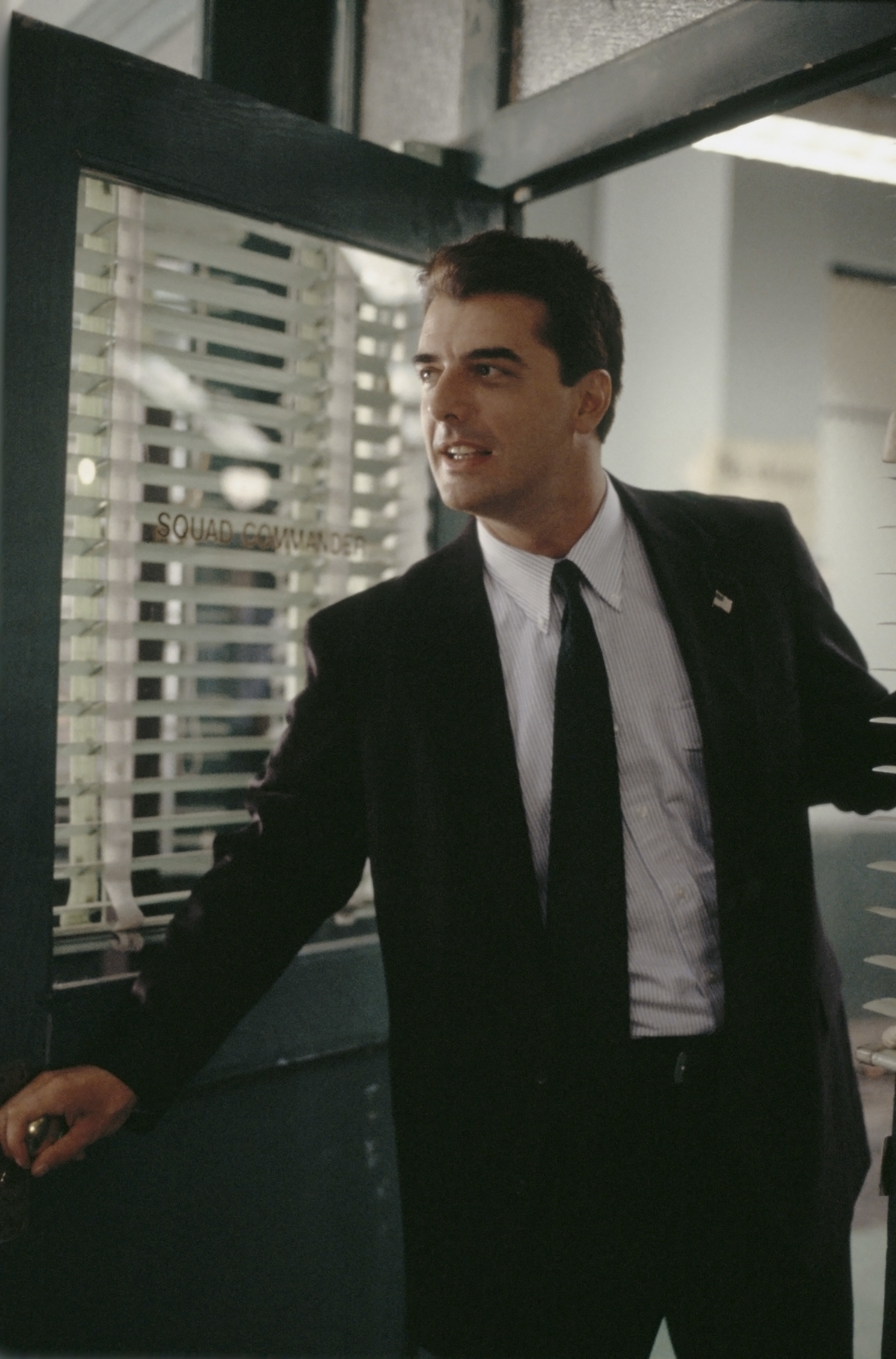 Chris Noth opening a door and leaning in while playing Detective Mike Logan in &quot;Law &amp; Order&quot;