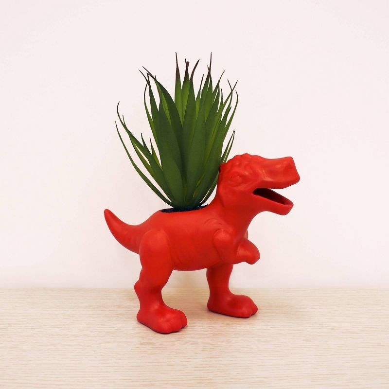 the red dinosaur planter with a faux succulent