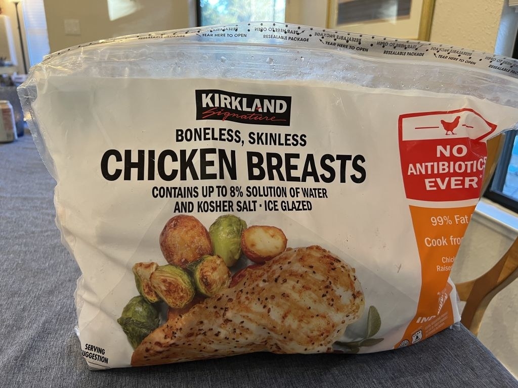 A bag of frozen Kirkland chicken breasts.
