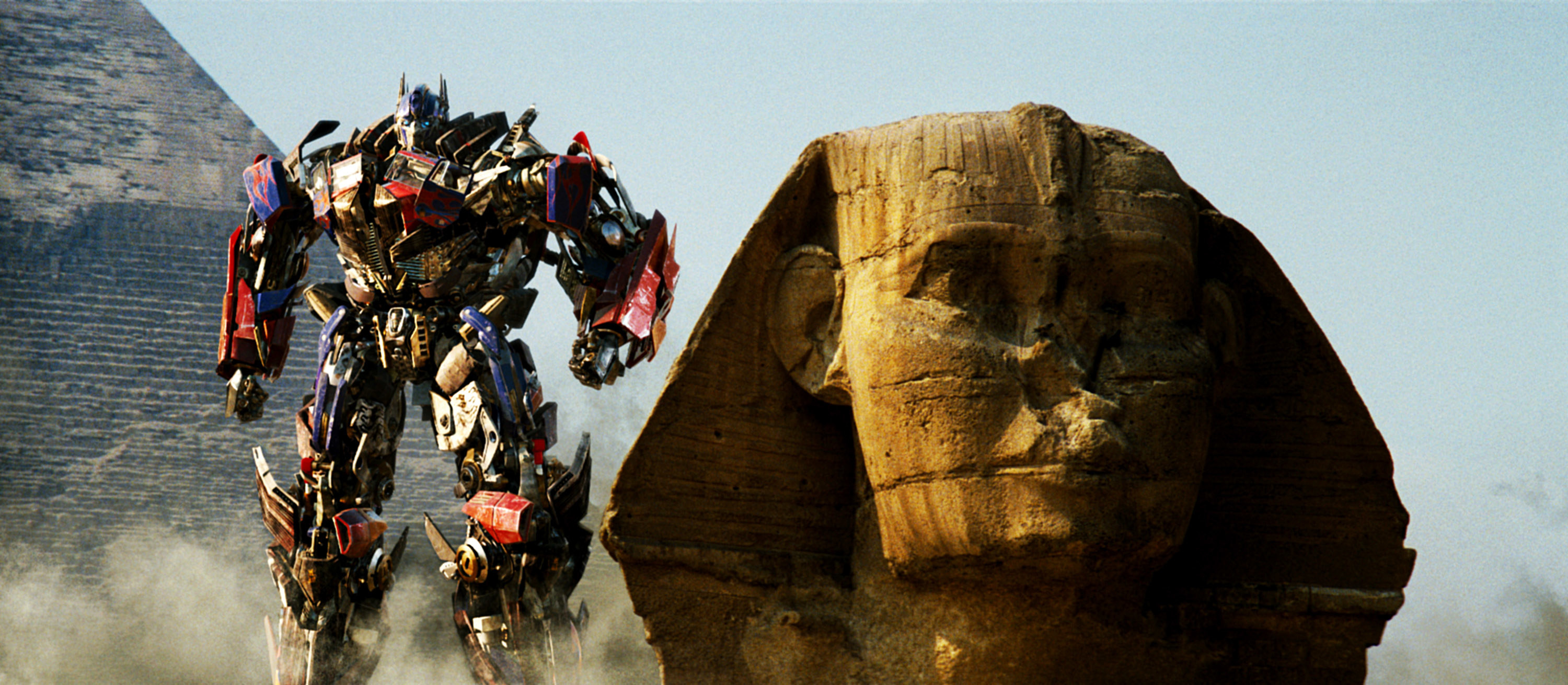 transformer next to a large egyptian statue