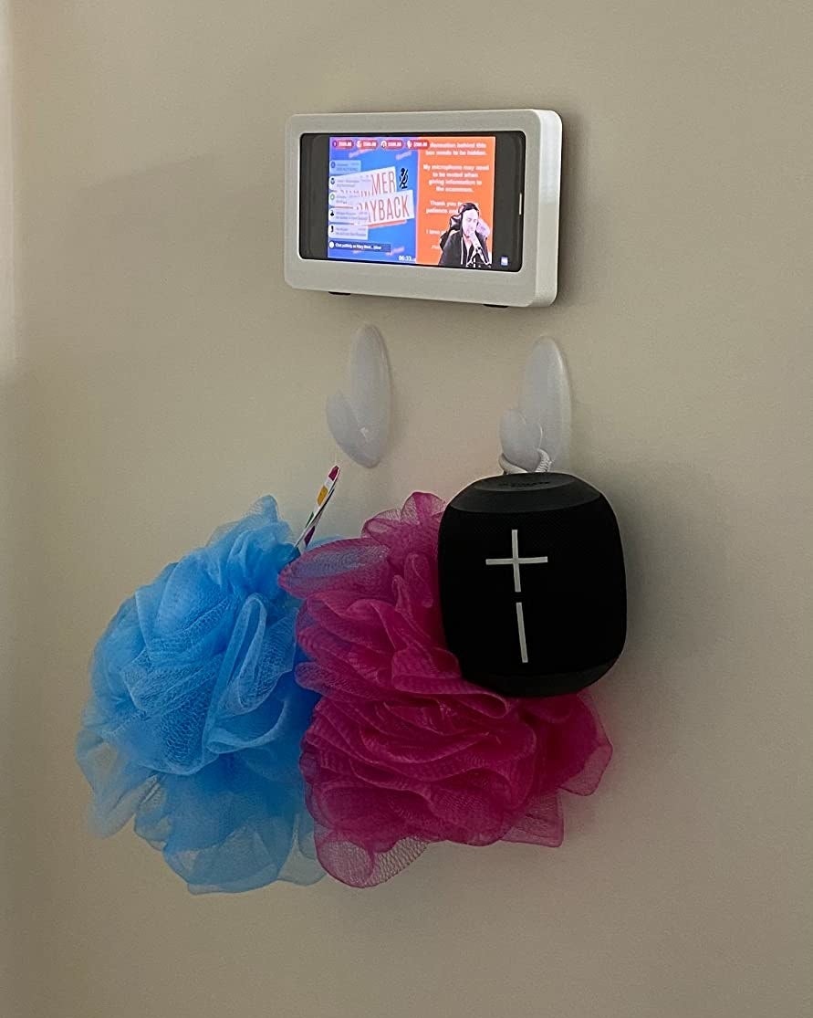 Reviewer's photo of the holder with a cell phone inside of it in a shower
