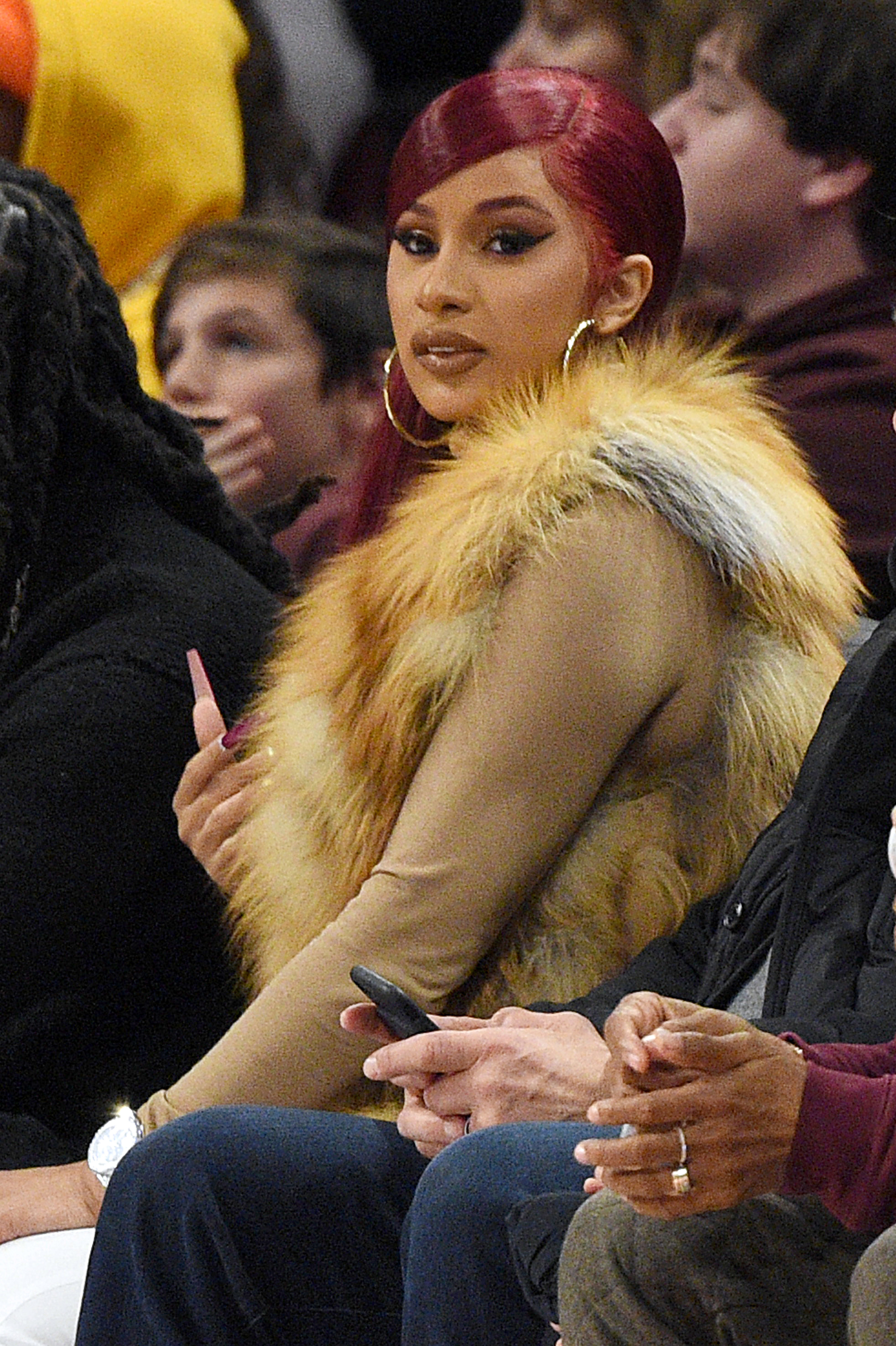 Cardi sitting court-side at a sporting event