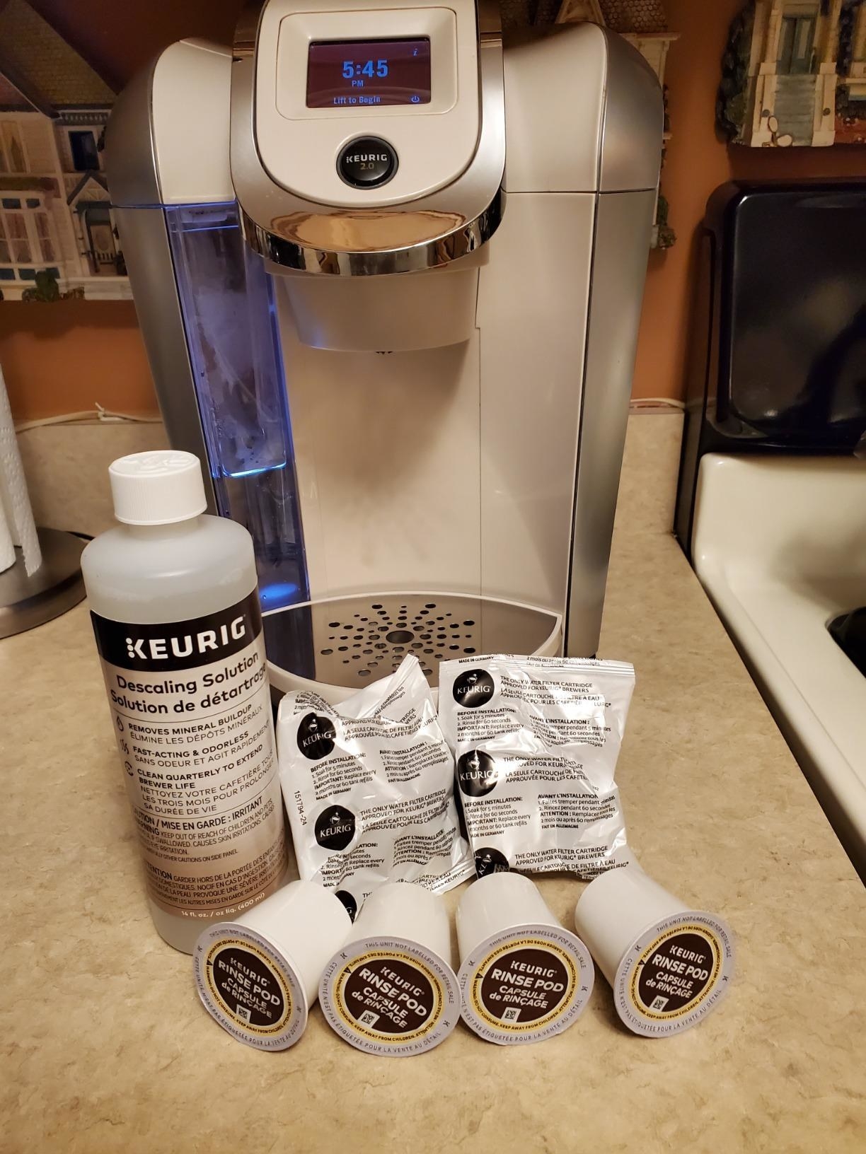 a reviewer photo of the contents of the cleaning kit set up in front of a Keurig