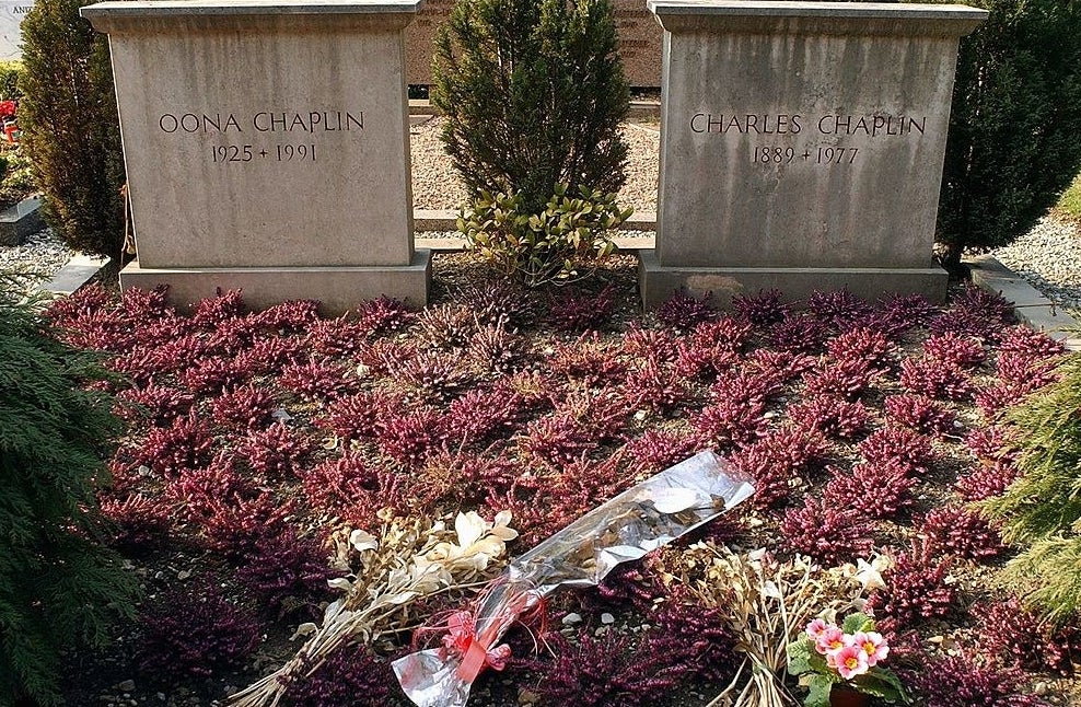 Two simple head stones with a bed of flowers in front