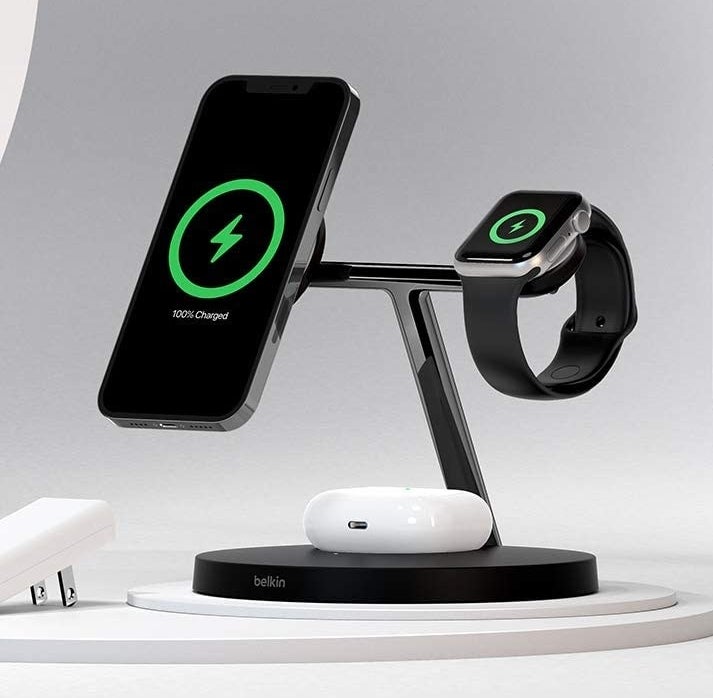 an iphone, apple watch, and airpods charging on the 3 in 1 charging station