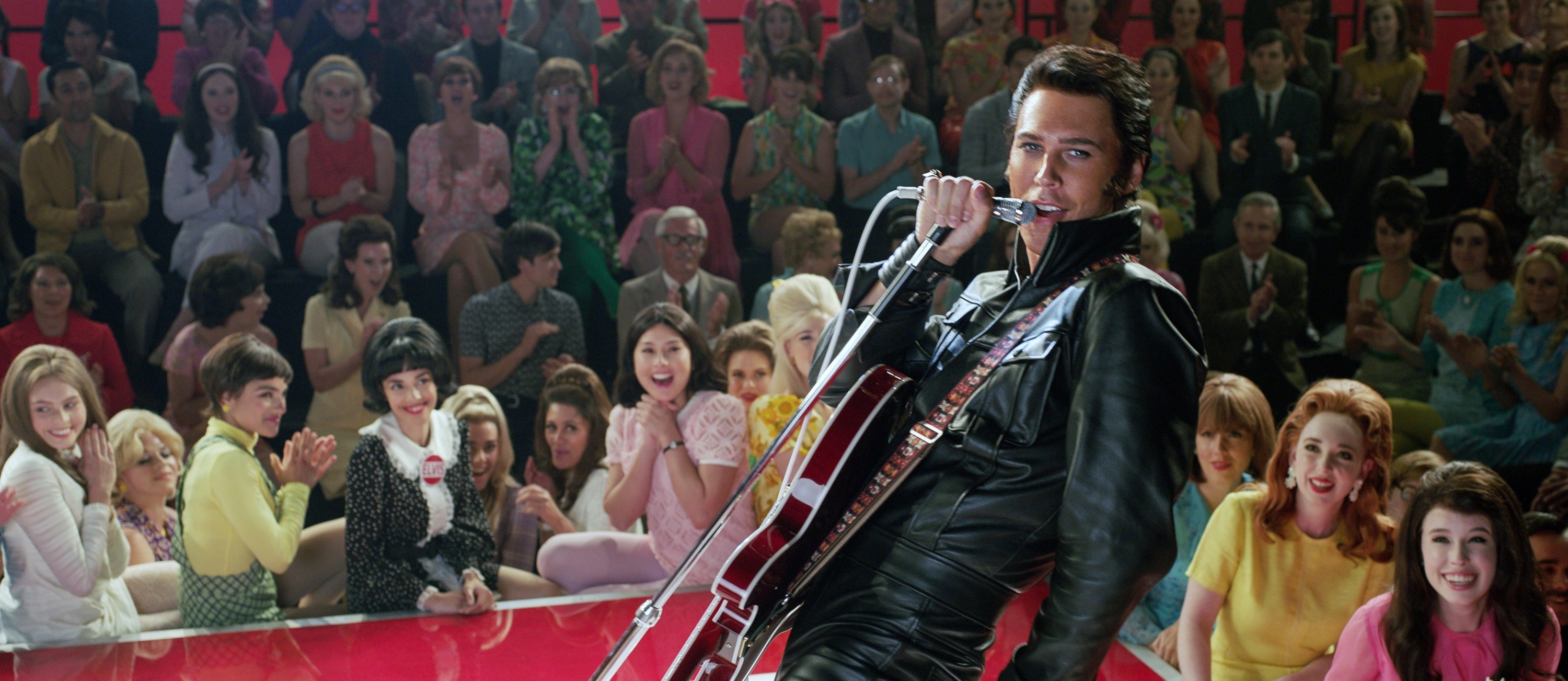 Austin performing onstage as Elvis in the film in a full leather outfit and a guitar slung over his shoulder