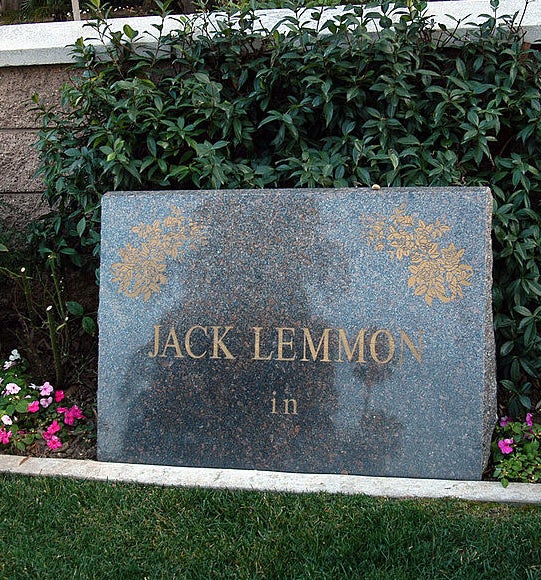A simple stone marker with Lemmon&#x27;s name and the word &quot;in&quot; below it over a plot of grass