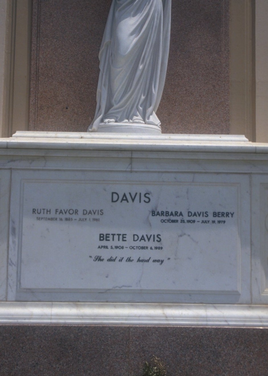 A large marble tomb with a statue of a woman on top