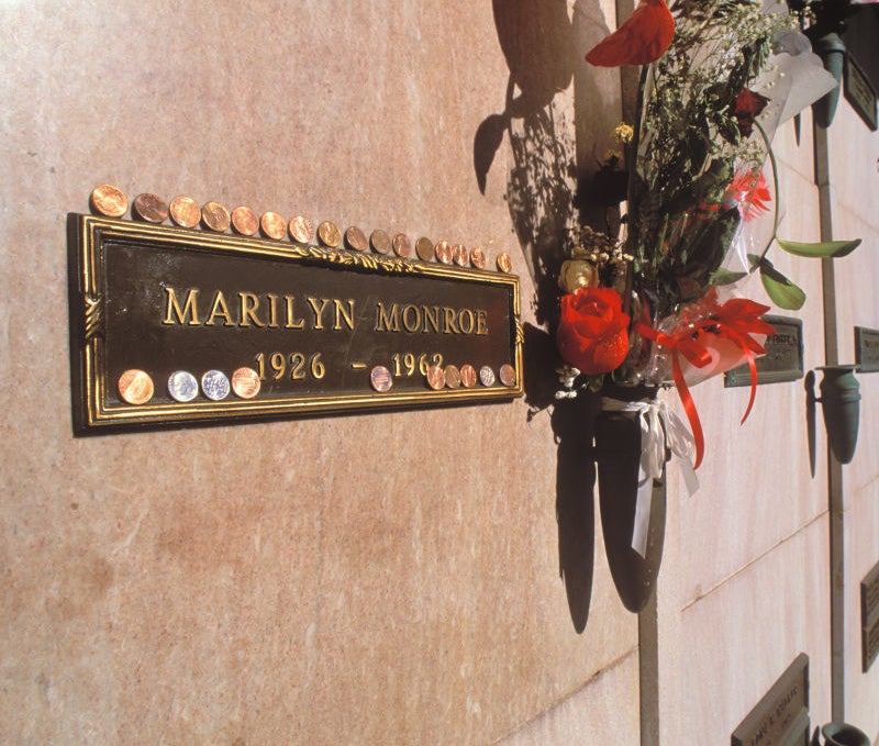 Plaque for Marilyn Monroe&#x27;s grave inside a crypt with pennies laid on top of it