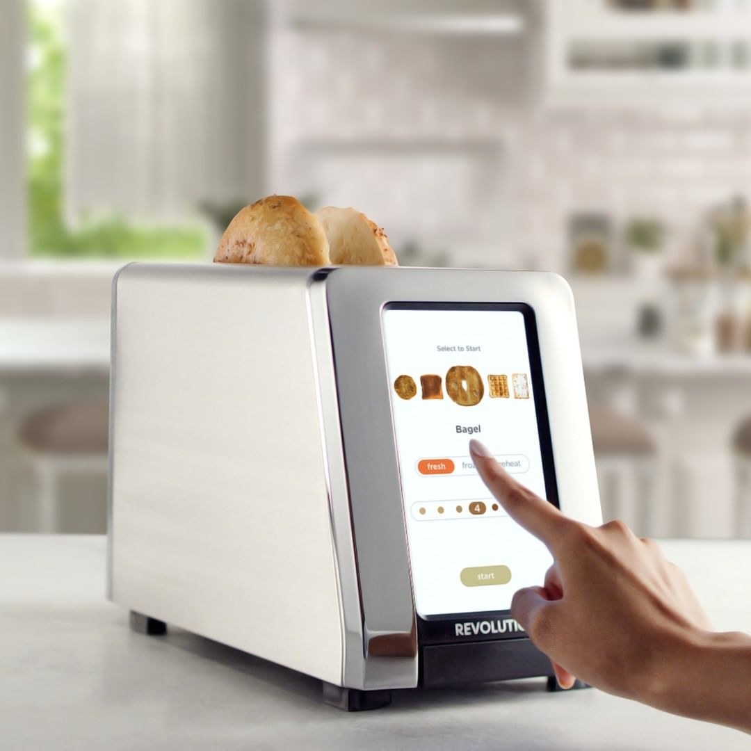 a person pressing a button on the touchscreen toaster