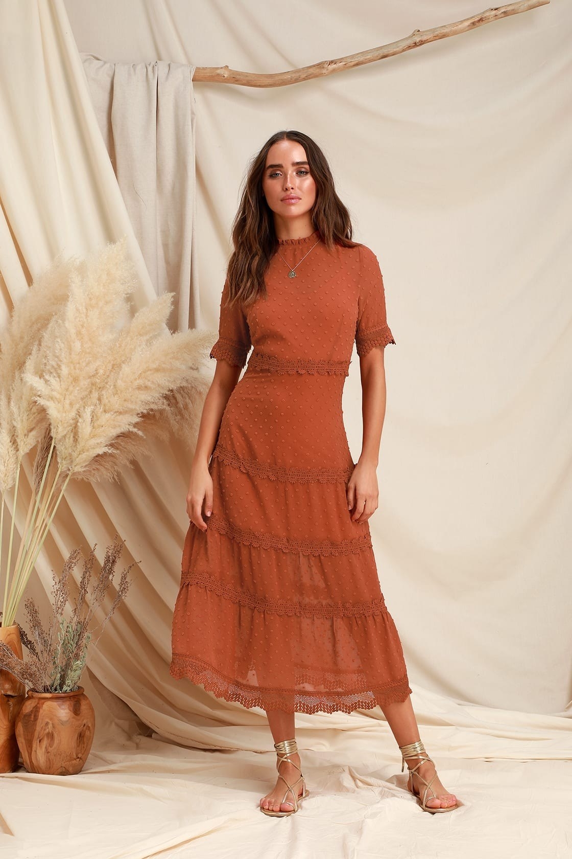 the model wearing the rust orange dress