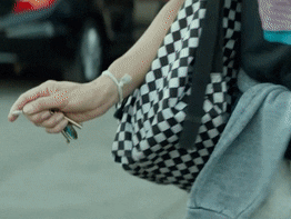 A woman scraping a car with car keys