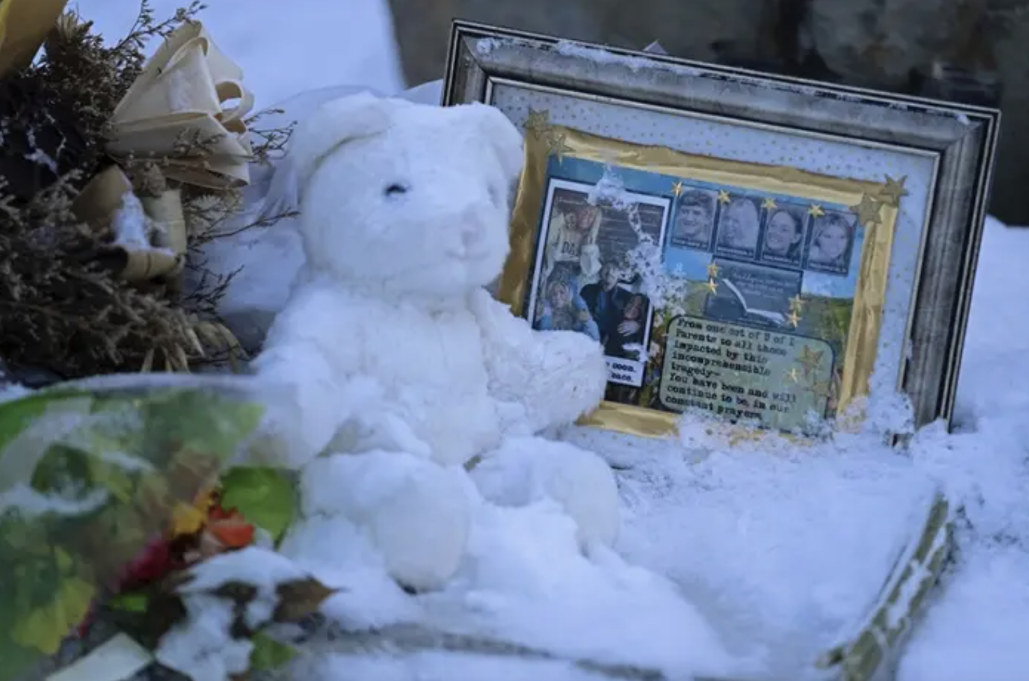 a stuffed white bear next to a framed photo of the deceased idaho murder victims