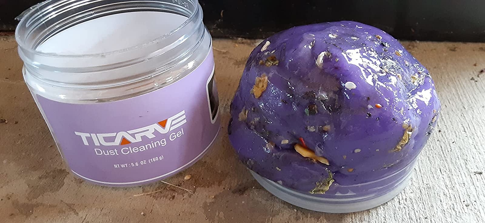 a reviewer photo of the purple cleaning gel with a ton of crumbs and particles stuck in it