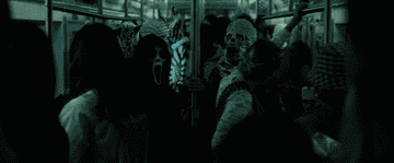 Several men in masks sit on a train
