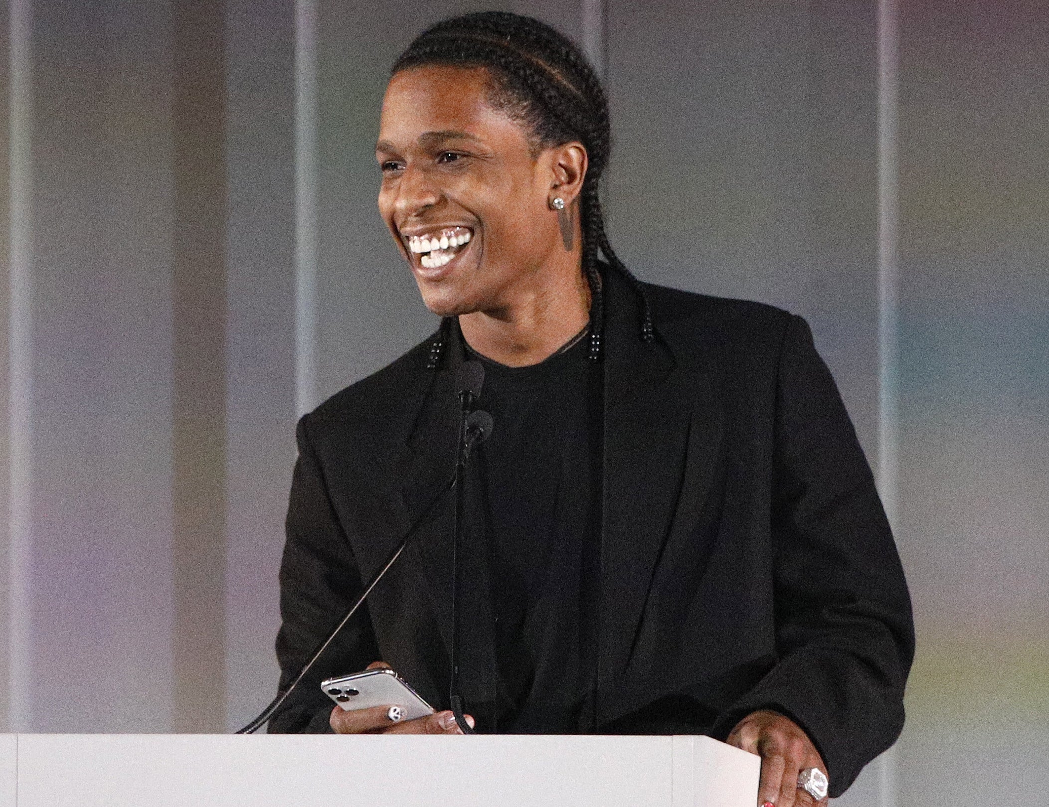 A close-up of A$AP smiling at a podium