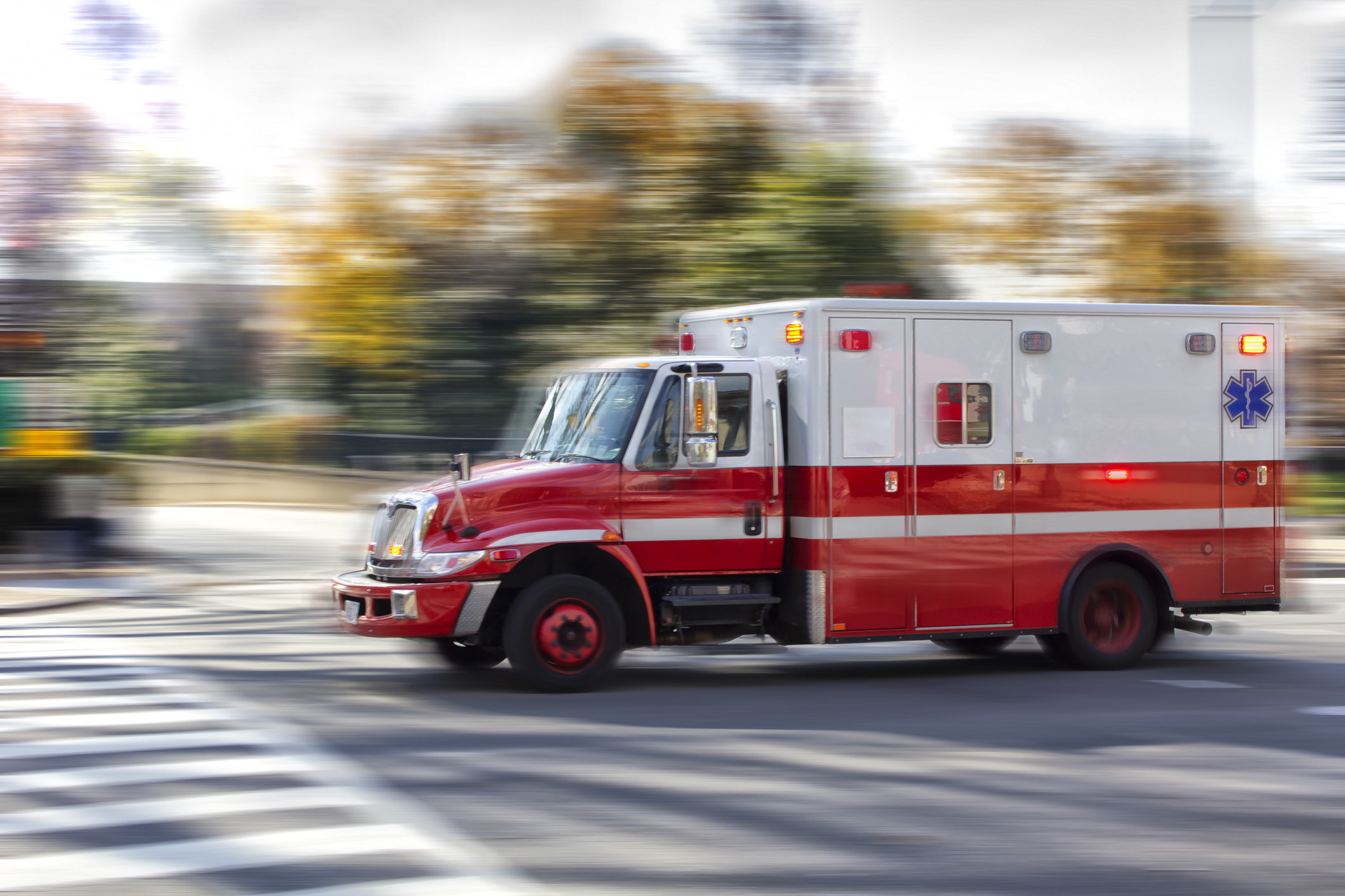Ambulance in motion on the street with blurred background indicating speed