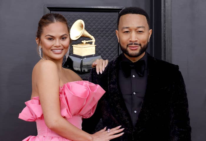 Chrissy with her hand on John&#x27;s shoulder as they pose for photographers on the Grammys red carpet