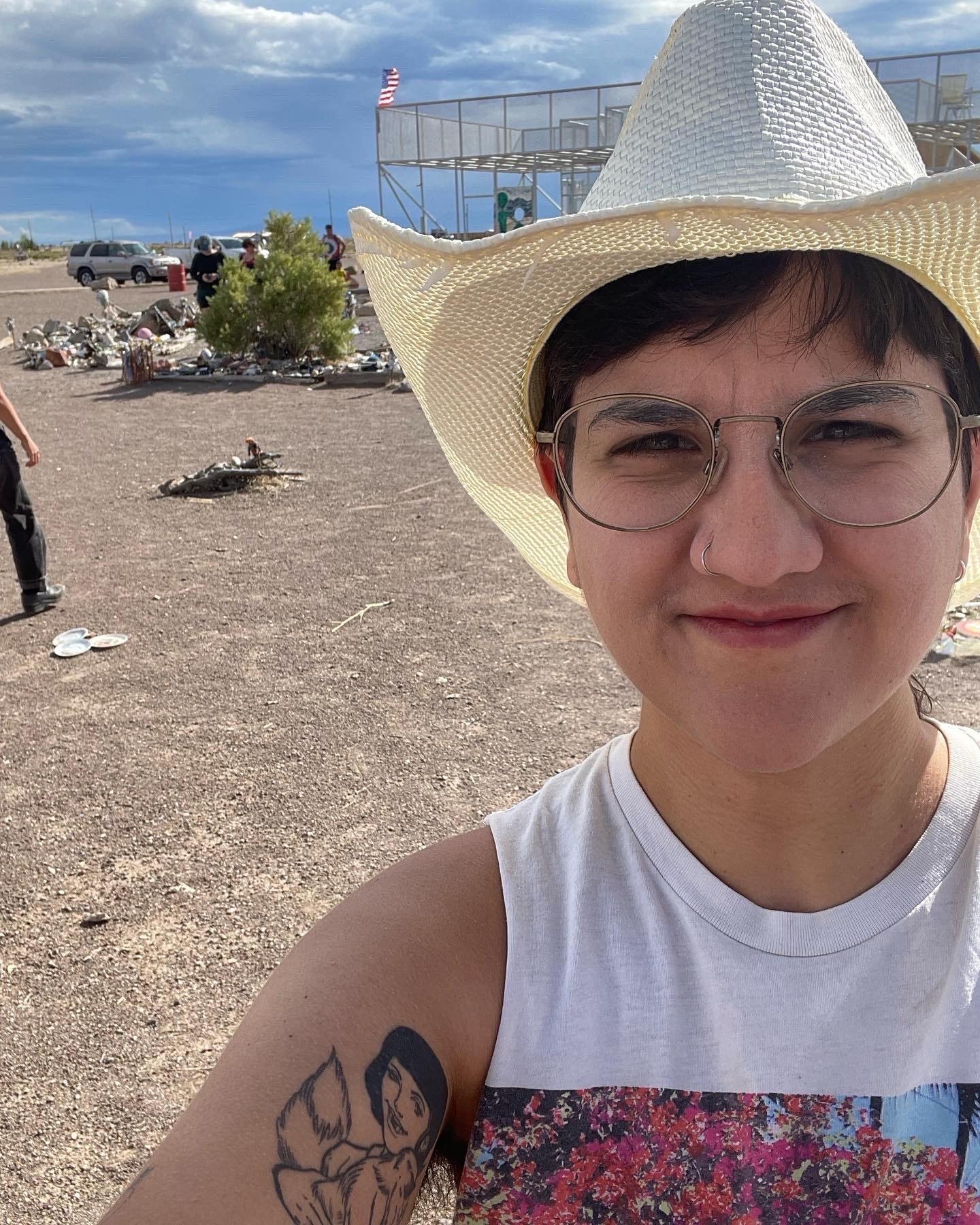 A transmasculine person takes a selfie in the desert.