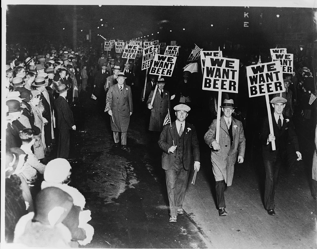 Men marching and holding signs saying &quot;We want beer&quot;