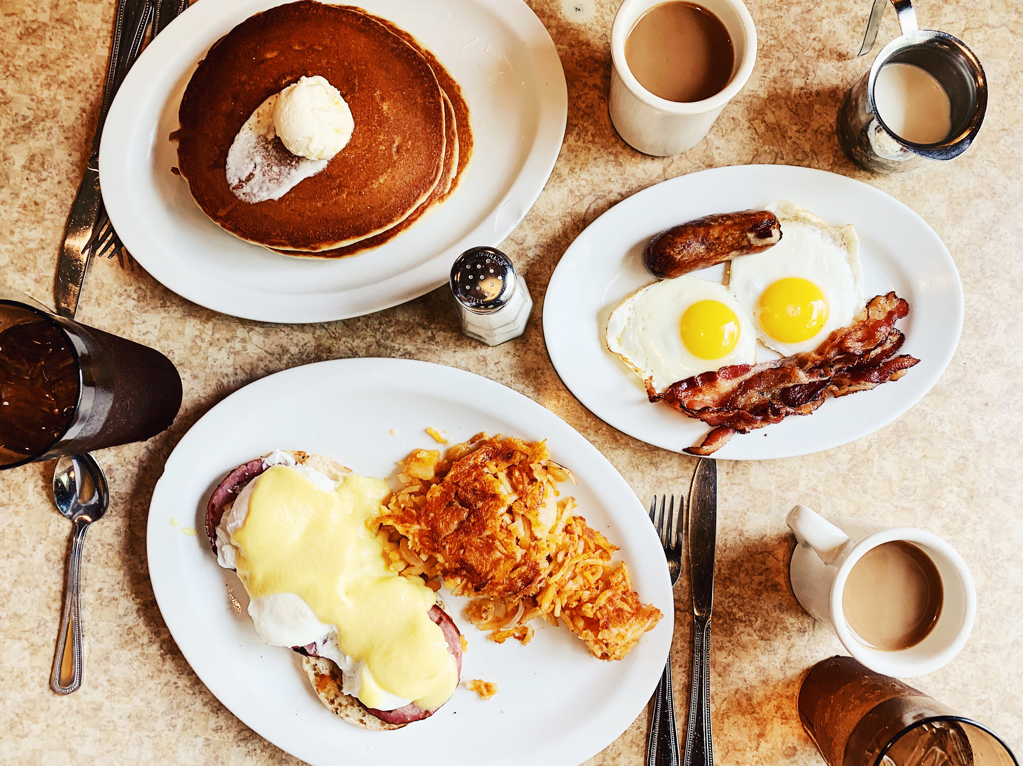 American breakfast with eggs, pancakes, and hash browns.