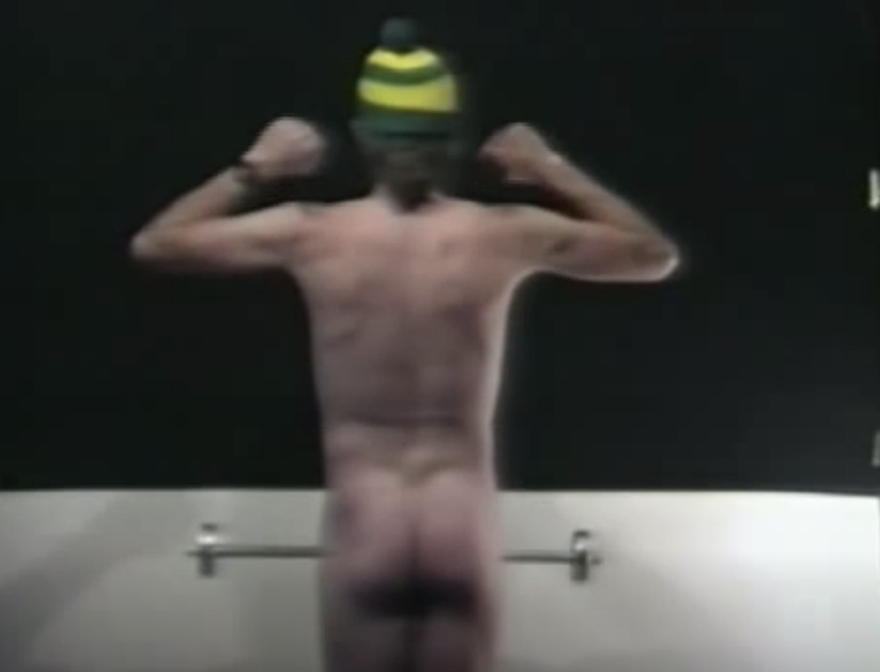 the man&#x27;s backside as he lifts a dumb bell