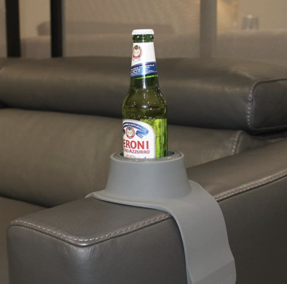the drink holder with a bottle of beer inside of it on the arm of a couch