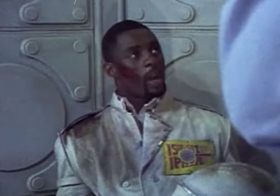 closeup of Idris in a dirty uniform