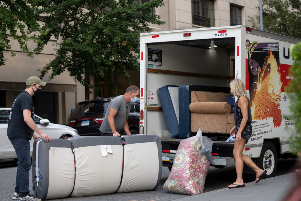 People putting belongings into a truck