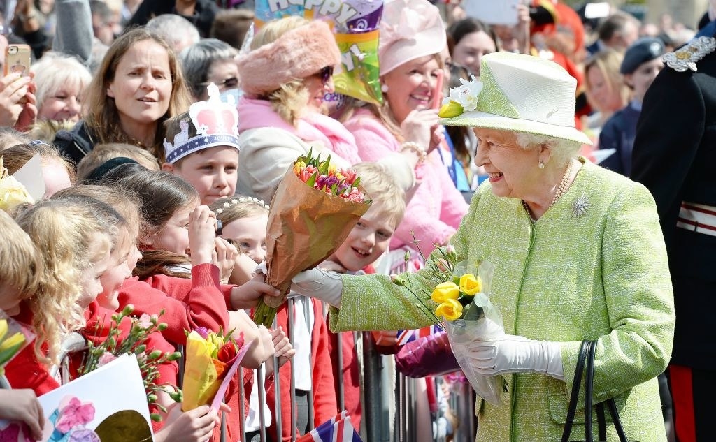 Queen Elizabeth meeting the public and holding flowers