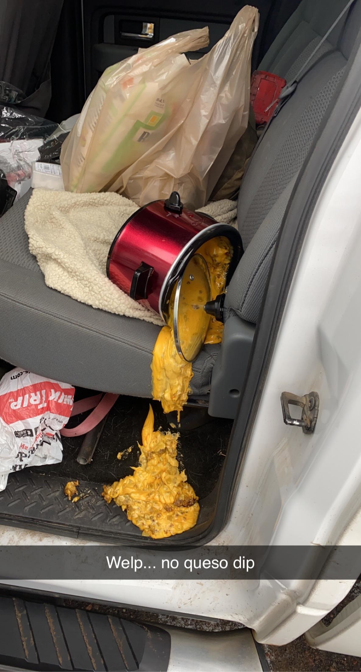A pot of queso dip spilled in a car