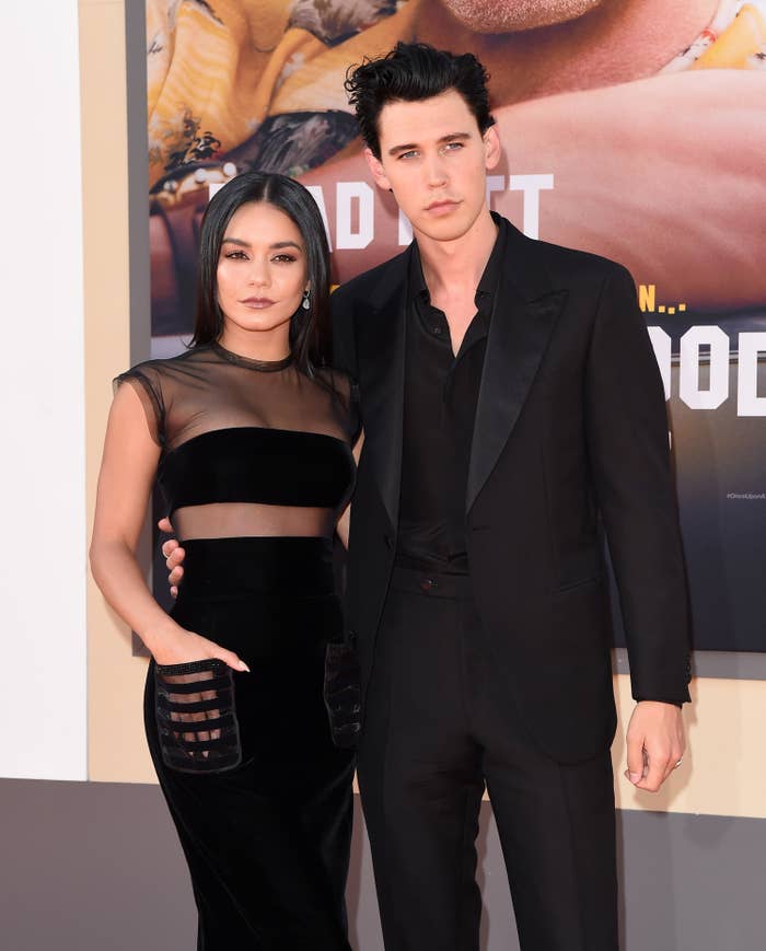 Austin and Vanessa with their arms around each other as they pose for photographers at a red carpet event