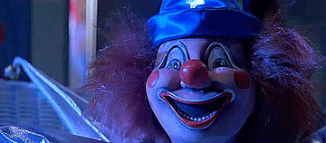 A smiling clown doll is lit up by lightning
