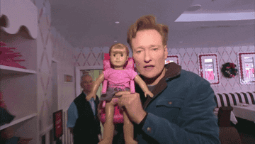 Conan O&#x27;Brien holds a doll next to his face