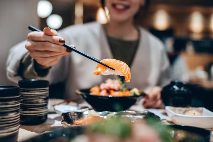 A woman eating sushi alone at a restaurant