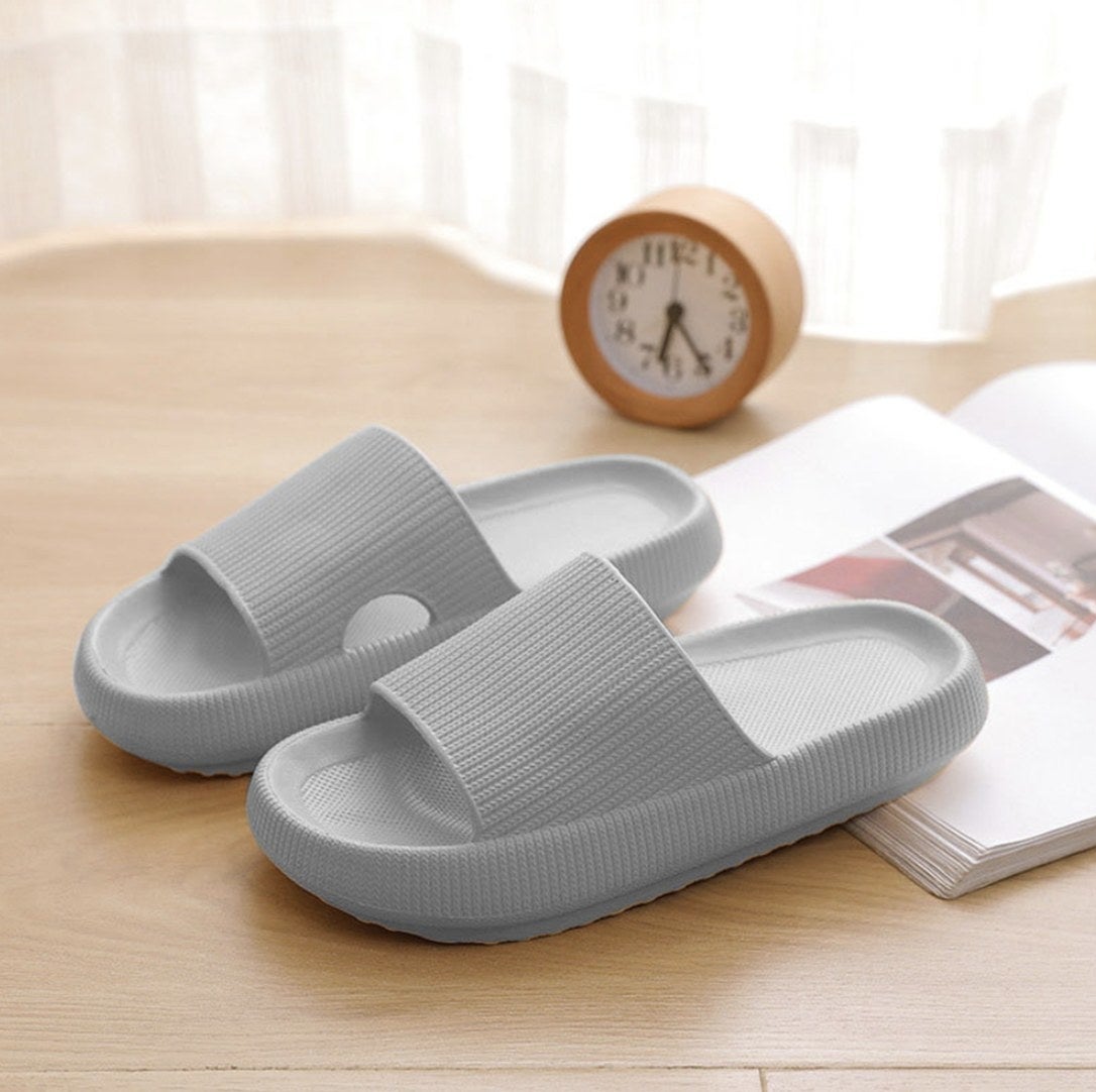 A pair of grey pillow slide sandals