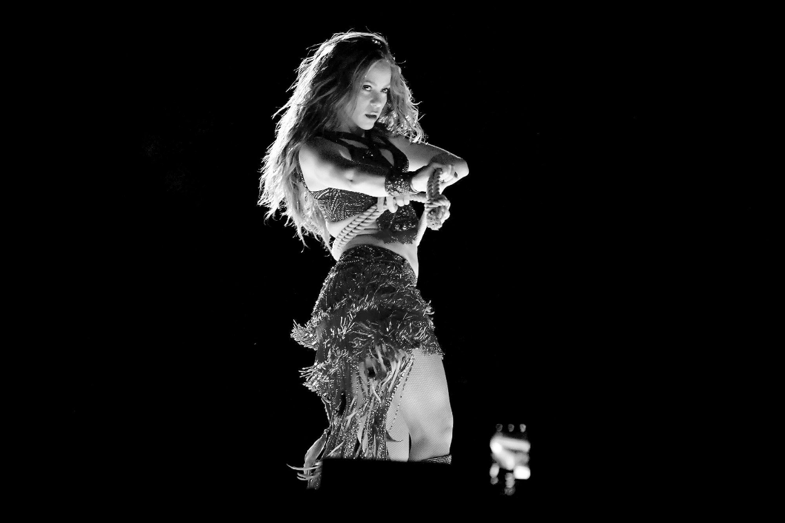 Shakira dancing onstage in black and white