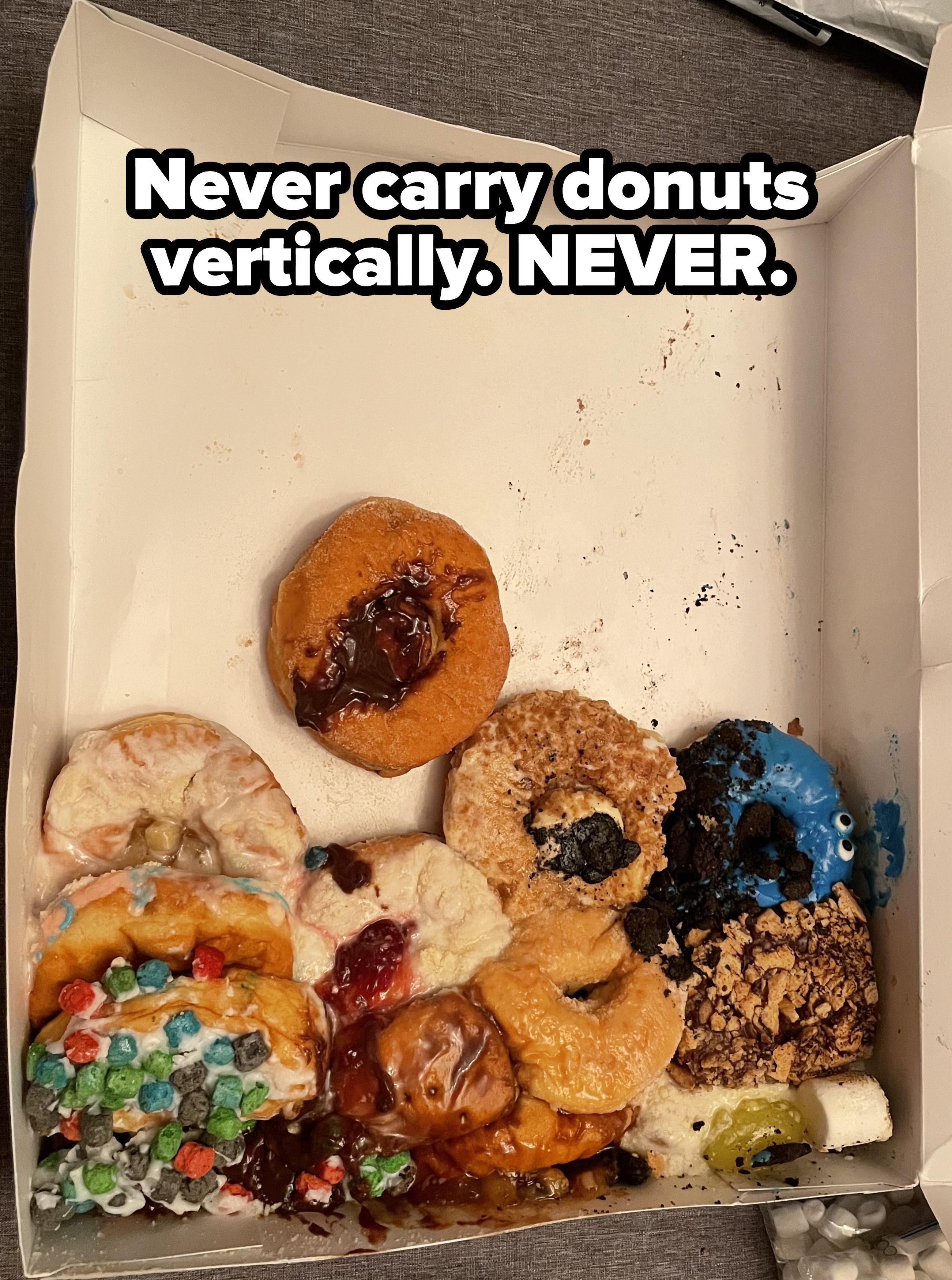 Donuts carried vertically that mushed together in the box