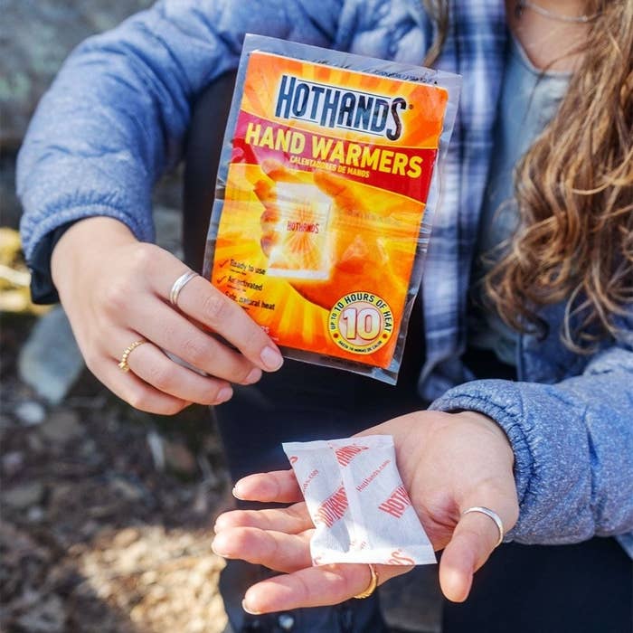 a person holding the hand warming packet in their hand