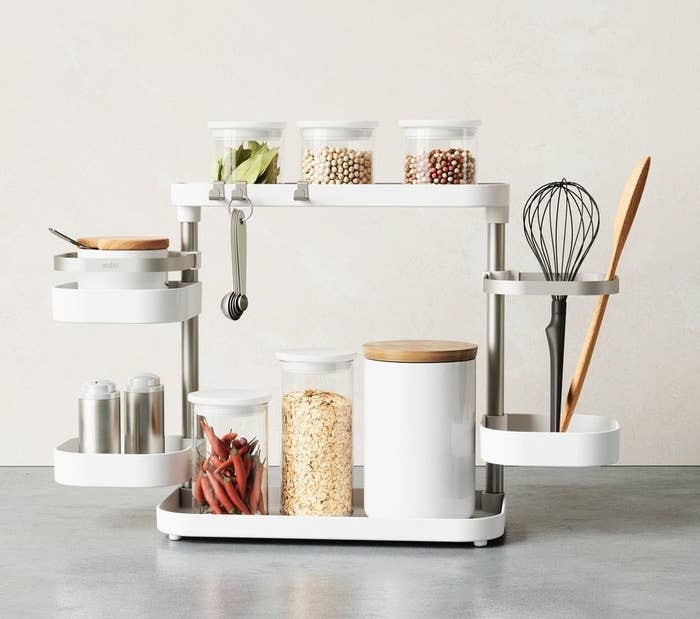 a multi-tiered kitchen organizer filled with kitchen essentials like spices and utensils