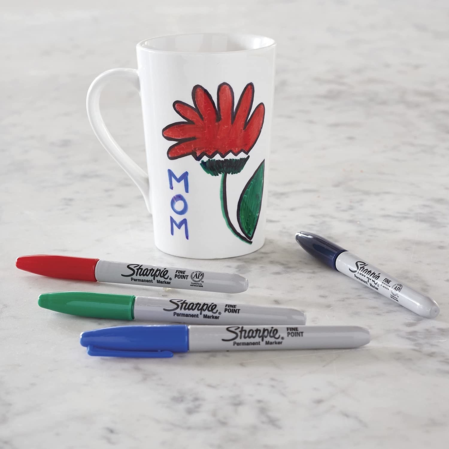 four sharpies next to a mug