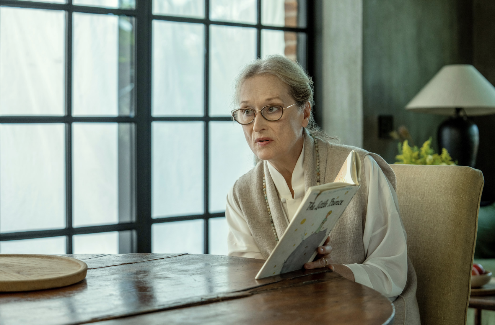 meryl streep&#x27;s character reading a children&#x27;s book at a dining table